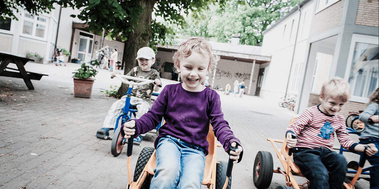 Kinder spielen ausgleassen auf dem Hof der Kita St. Marien Ottensen